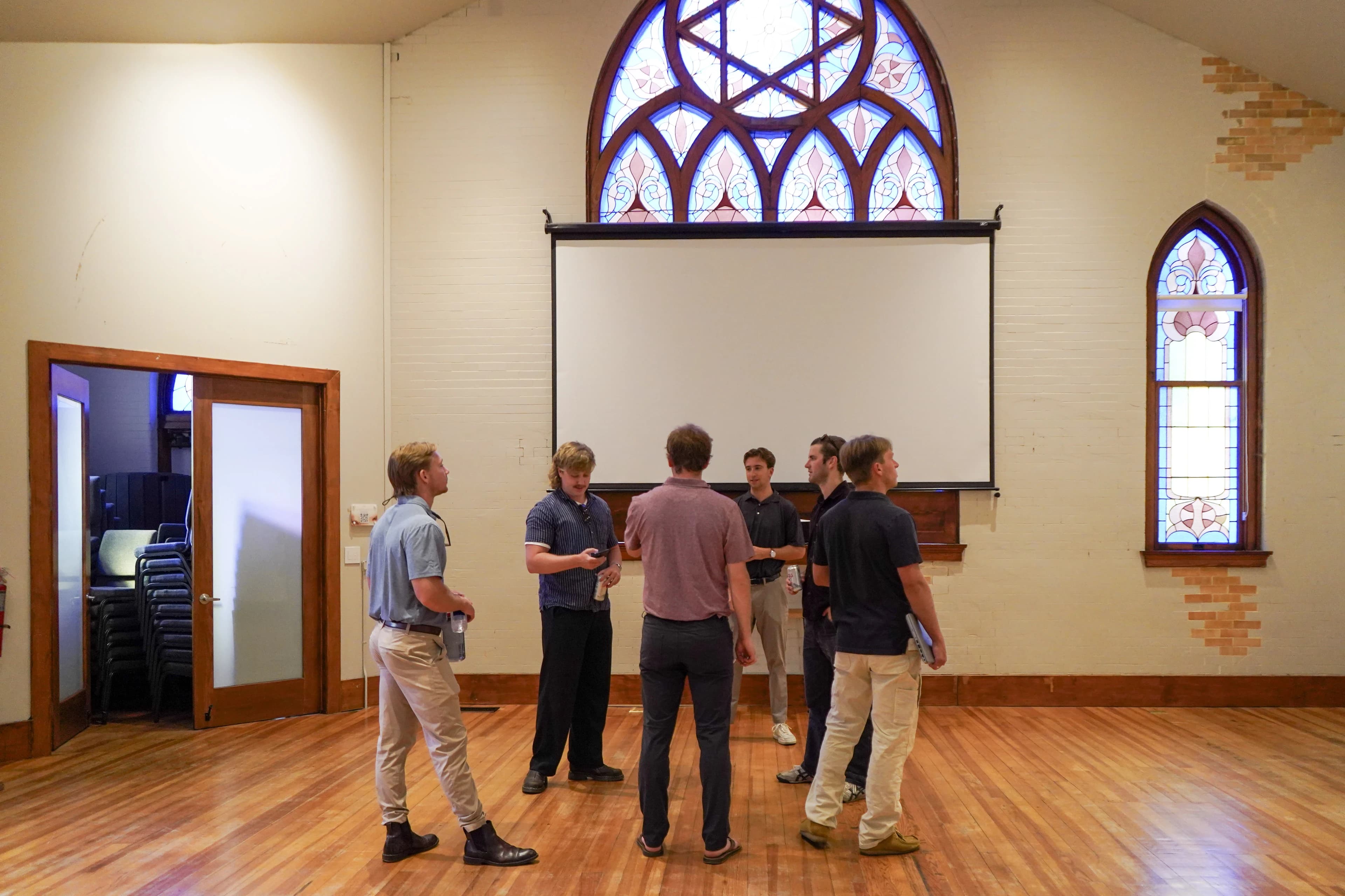 Members working together under the rose window in the restored 1905 flex space at Merritt Workspace, Sloan's Lake, Denver
