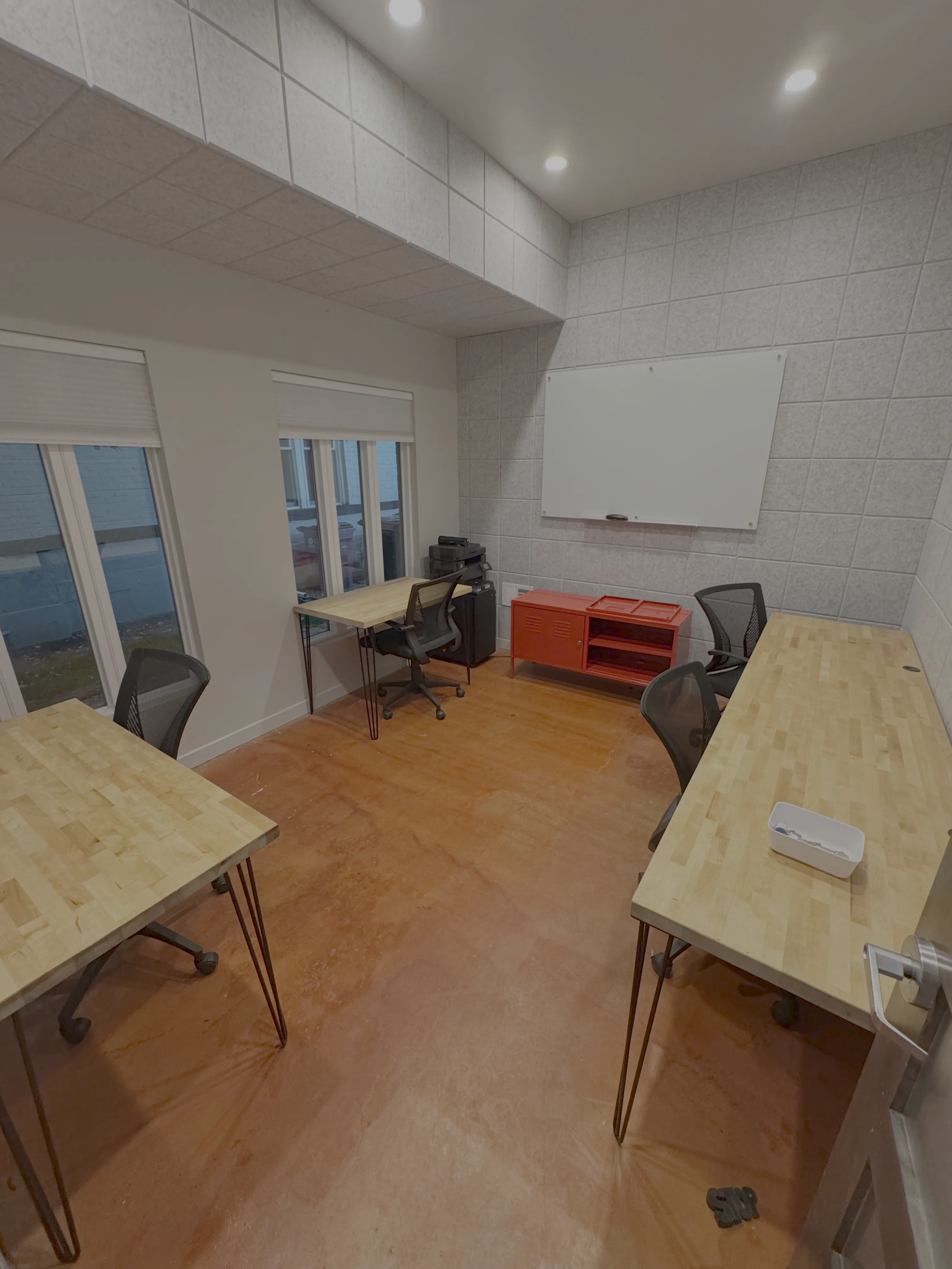 The large private office at Merritt Workspace, Denver, with butcher block desks and a whiteboard